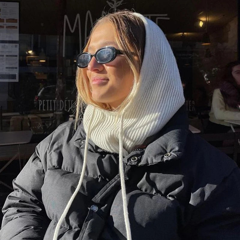 Stylish woman wearing a knit pullover balaclava for women in a cozy outdoor cafe