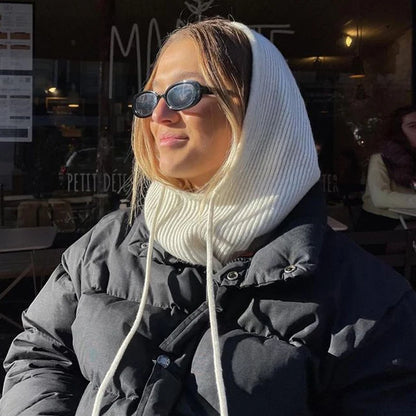 Stylish woman wearing a knit pullover balaclava for women in a cozy outdoor cafe