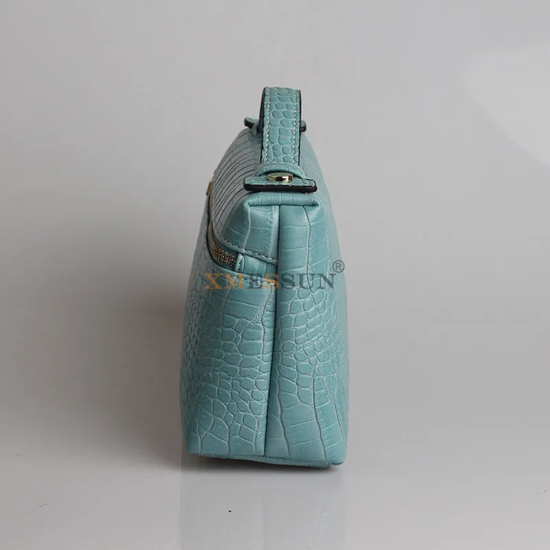 Side view of a luxurious faux crocodile makeup bag in blue with a sleek design and stylish finish