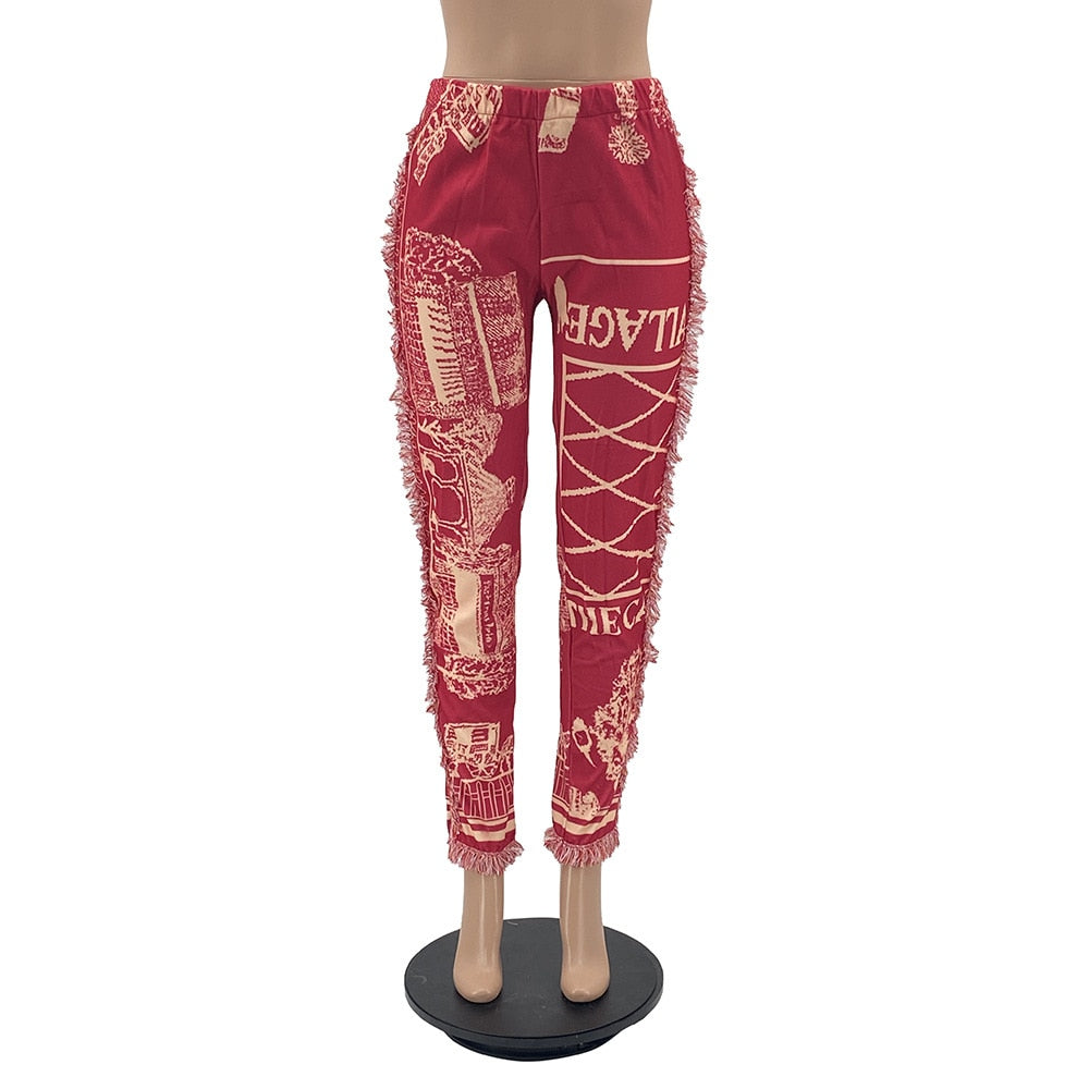 Red tassel patchwork striped pants with elastic waistband and ankle cuffs featuring cream graphic prints
