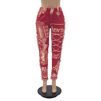 Red tassel patchwork striped pants with elastic waistband and ankle cuffs featuring cream graphic prints