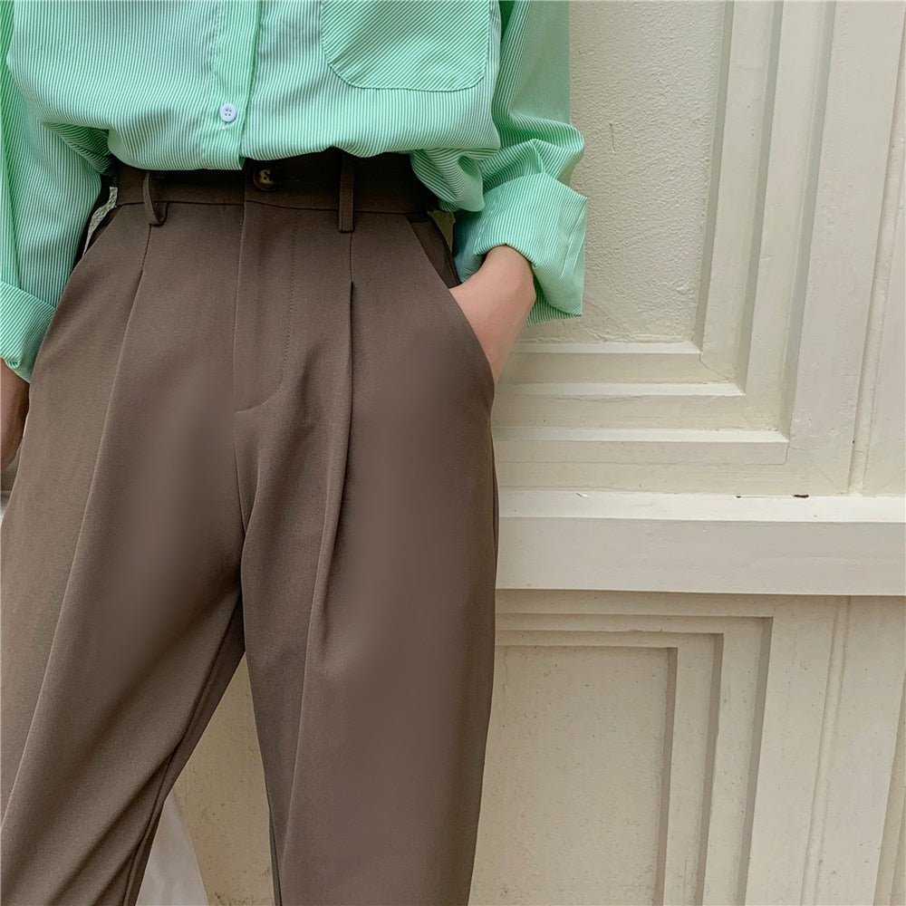 Woman wearing brown high waist pleated Formal straight leg suit office trousers for women. Side pockets and tailored crease