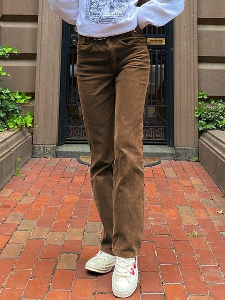 EtherealBe brown thin corduroy pants for women styled with white sneakers and sweatshirt on brick walkway