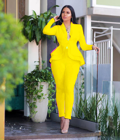 Woman in bright yellow women ruffle blazer pants set posing outdoors by planters and stairs