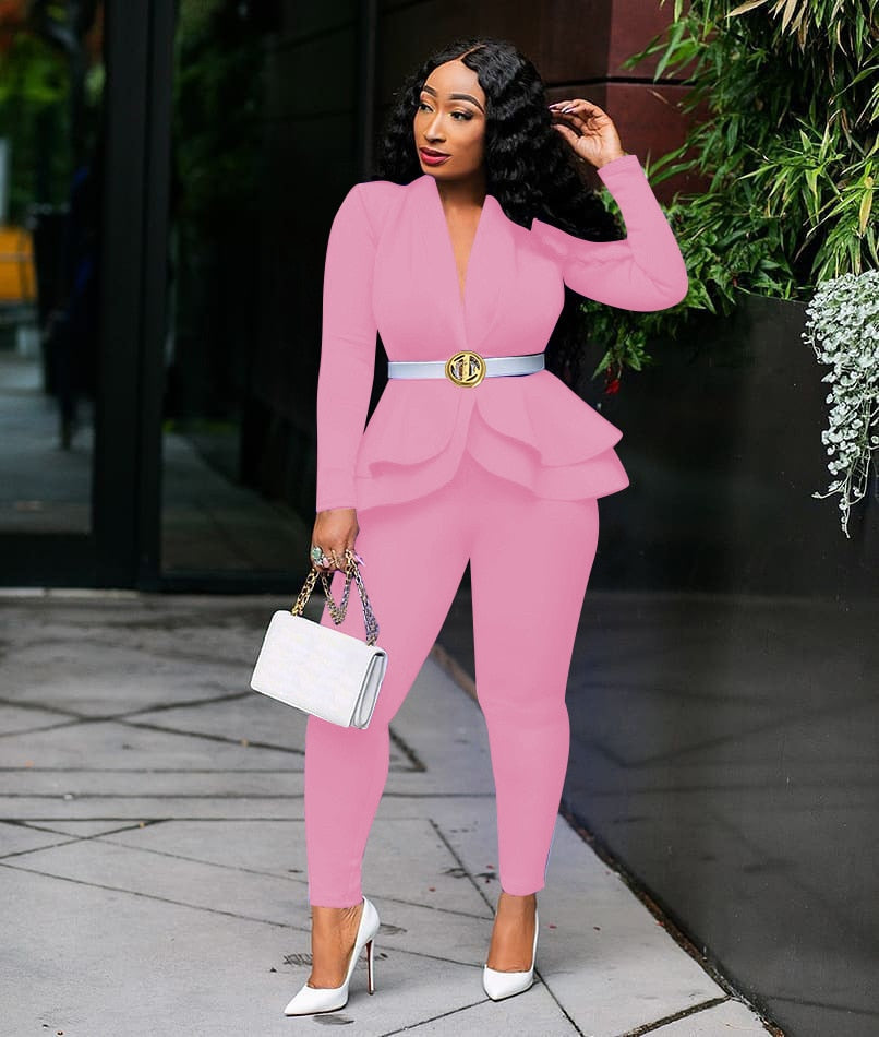 Model wearing pink women ruffle blazer pants set with peplum belt white heels and handbag outdoor