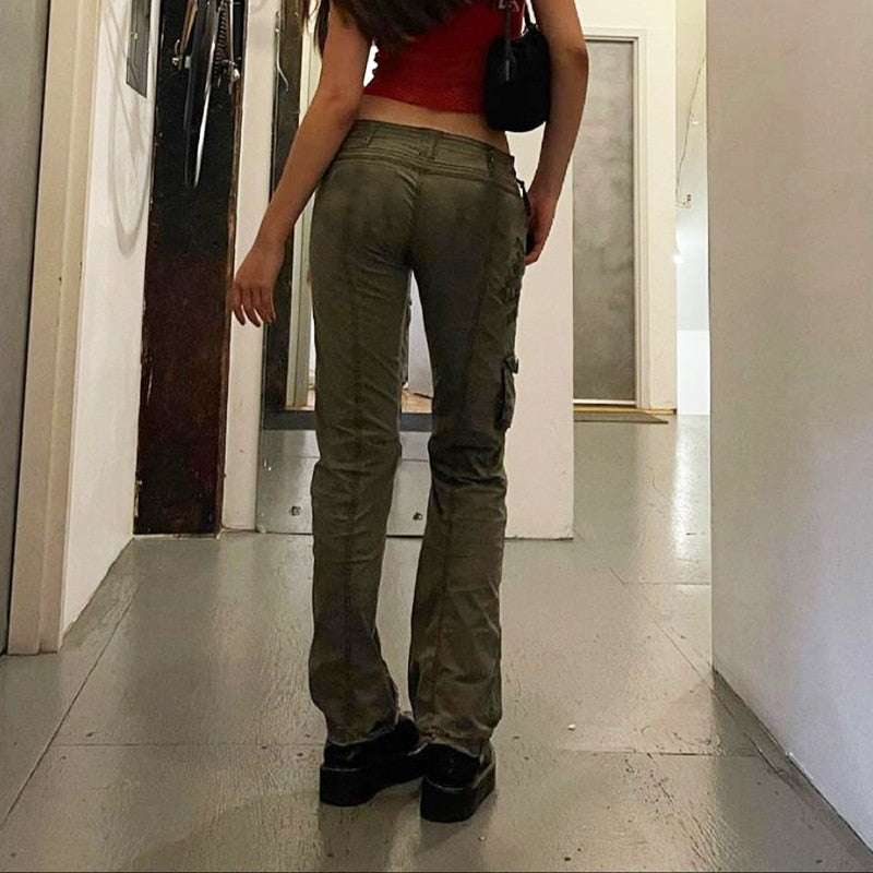 Rear view model wearing olive grunge streetwear straight leg pants with cargo pockets and platform shoes