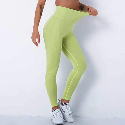 EtherealBe lime green high waist seamless push up gym leggings on model stretching waistband
