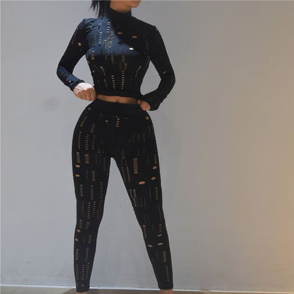 Model wearing black cutout women's biker style two piece set with long sleeve crop top and high waist leggings