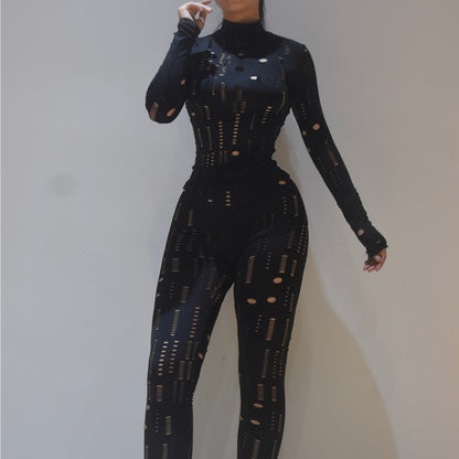 Model wearing black cutout high neck fitted women's biker style two piece set with long sleeves and leggings