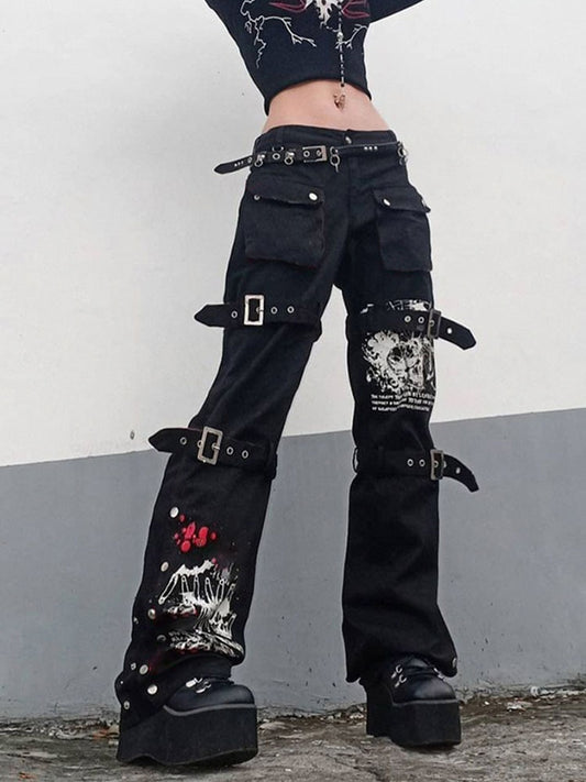 Model wearing black buckle eyelet pocket goth pants with cargo pockets buckles straps and white skull print