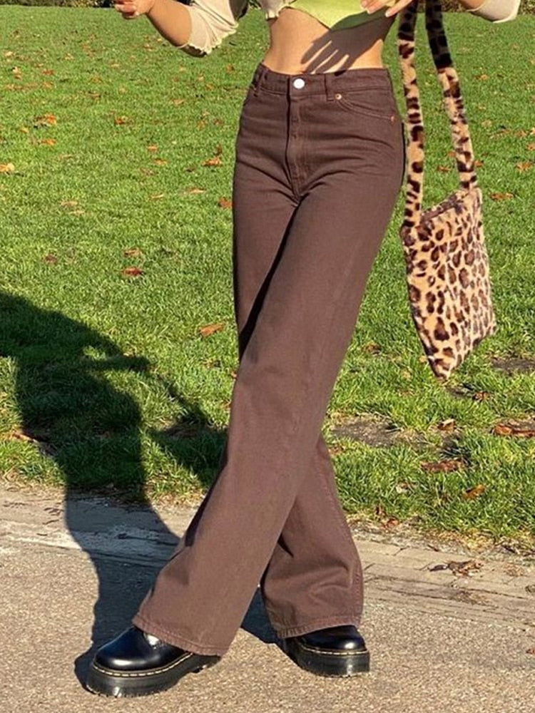 Model wearing brown vintage high waist wide leg pants with cropped top leopard tote bag and platform boots
