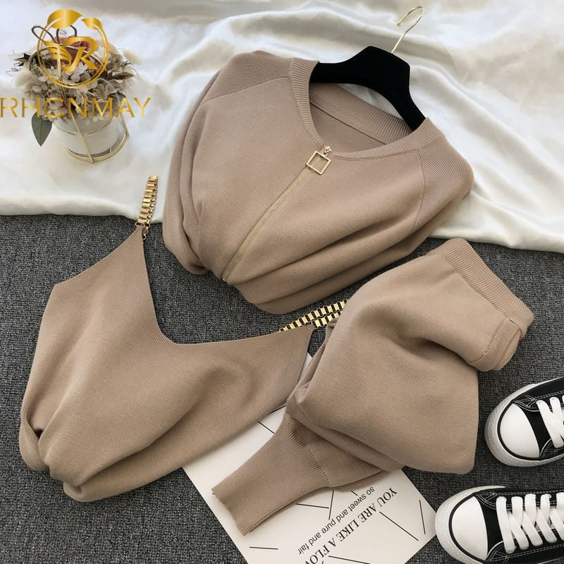 Beige knit sweater and pants outfit for women laid flat with gold zipper detail bag and sneakers