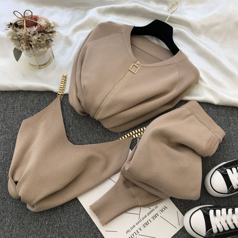 Beige knit sweater and pants outfit for women laid flat showing zip sweater matching pants bag and sneakers