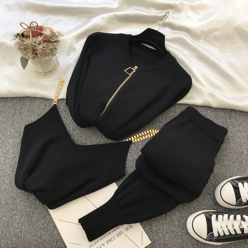 Black knit sweater and pants outfit for women flat lay with zip sweater gold chain cami and high waist pants