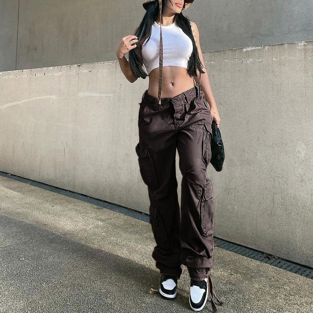 Model wearing EtherealBe women's low waist cargo jeans in dark brown with white crop top and sneakers