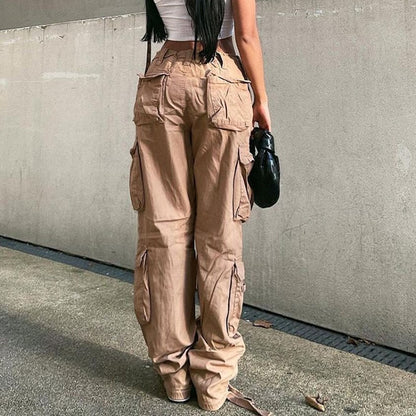 Back view of model wearing women's low waist cargo jeans in beige with multiple pockets and baggy fit