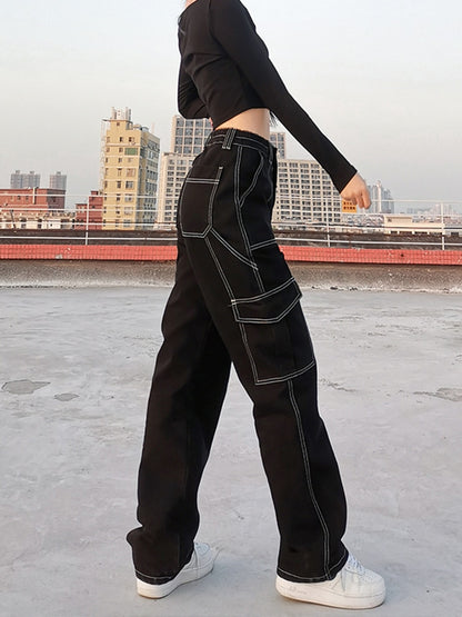 Side profile of black baggy cargo jeans for women with white contrast stitching and large side pockets
