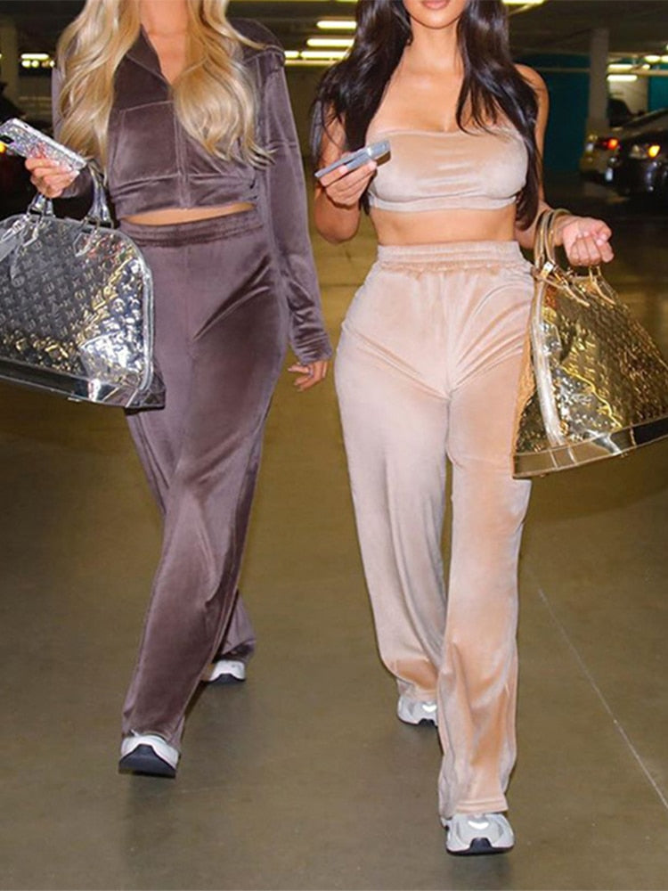 Two women wearing sporty velvet crop top 3pc tracksuit for women in beige and brown with sneakers and metallic tote bags