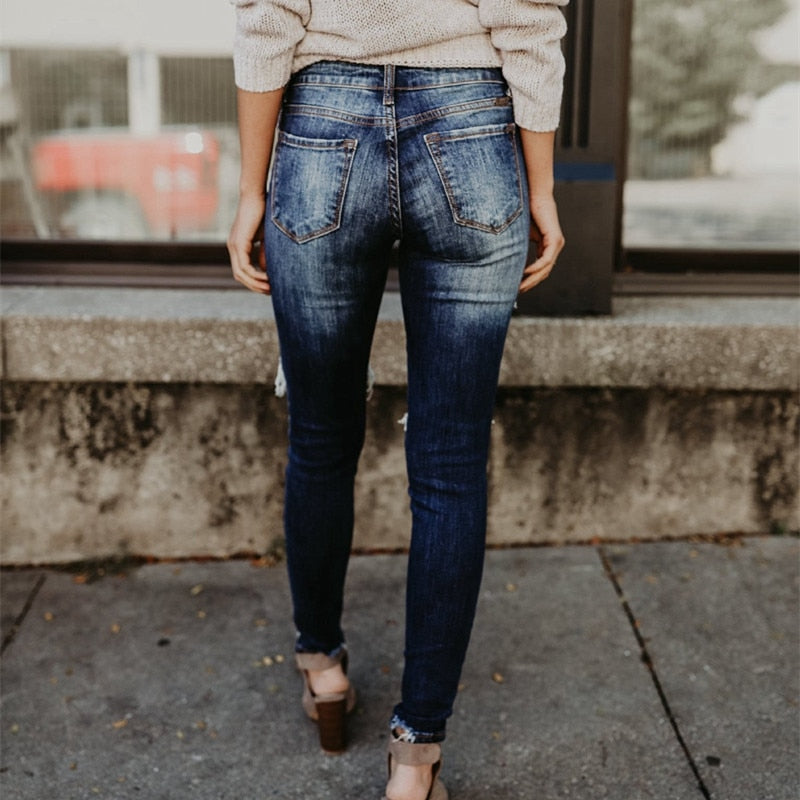 Back view of woman wearing cuffed dark distressed denim boyfriend ripped jeans for women in casual street style