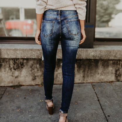 Back view of woman wearing cuffed dark distressed denim boyfriend ripped jeans for women in casual street style